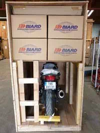 Box contenant des cartons de déménagement BIARD ainsi qu'une moto